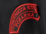 the back of a black jacket with a red patch on it