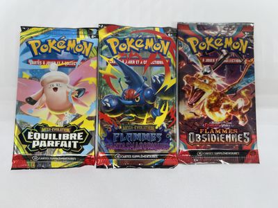 three packs of pokemon trading cards on a white surface
