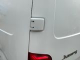 a white van parked in a parking lot with its door open