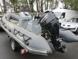 a boat with a motor attached to it parked in a parking lot