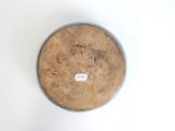 a brown bowl with a label on it sitting on a white surface