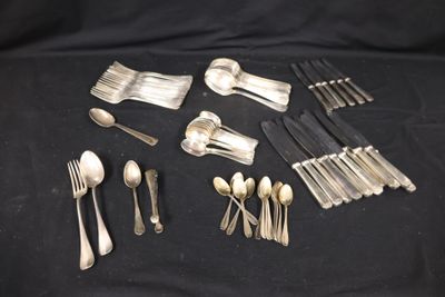 a lot of silverware on a black table cloth