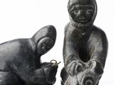 two statues of a man and a dog on a table