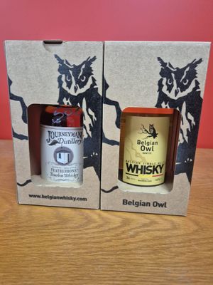 deux bouteilles de whisky dans une boîte en carton posée sur une table