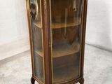 une vitrine ancienne avec une porte vitrée et des moulures dorées
