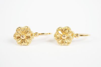 a pair of gold flower earrings on a white background