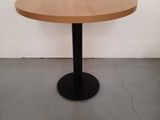 a round wooden table with a black metal base