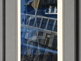 framed photograph of a reflection of a building in the window of a building