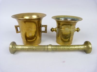 two brass vases on a white surface
