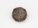 an old silver coin with a crown on it sitting on a white surface