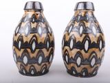 two vases sitting side by side on a white surface