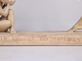 statue of a man and woman sitting on top of a wooden base