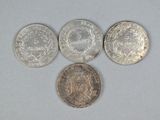 four different types of coins are shown on a white surface