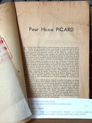 un livre ouvert posé sur une table à côté d'une feuille de papier