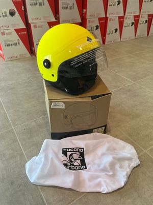 un casque jaune posé sur une boîte en carton, sur un sol carrelé