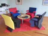 brightly colored chairs and a table in a living room with wood flooring