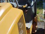 a yellow tractor that is parked next to a fence