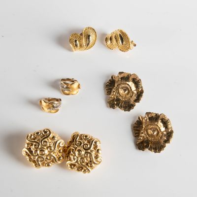 a group of gold jewelry on a white surface