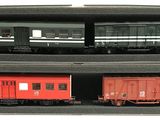 deux wagons rouges dans une boîte posée sur une surface blanche
