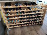 bottles of wine are stacked on a wooden rack in a store