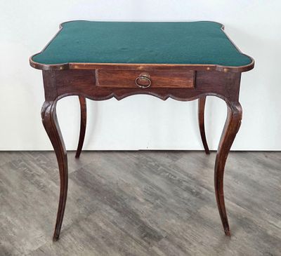 une petite table en bois avec un plateau vert, posée sur un parquet en bois dur