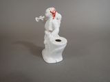 a statue of a man sitting on a toilet with a pipe in his mouth