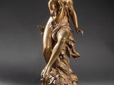 une statue en bronze d'une femme tenant un oiseau sur un piédestal