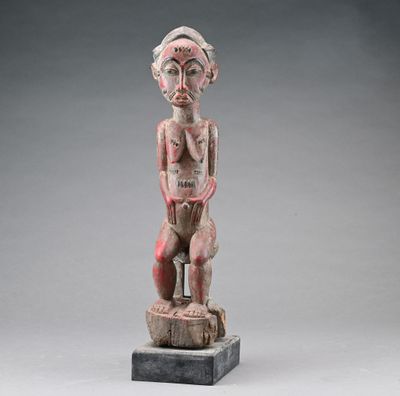 une statue en bois d'un homme avec un chapeau sur la tête