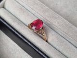 Gros plan sur une bague contenant une pierre rouge