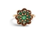 gros plan d'une bague en or avec une pierre verte