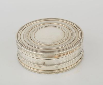 a silver plate with a circular design on it on a white surface
