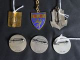 four medals are displayed on a black cloth with white string