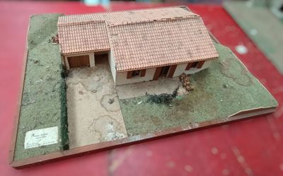 a small model of a house on a red table