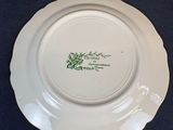 a white plate with a green design on it sitting on a table