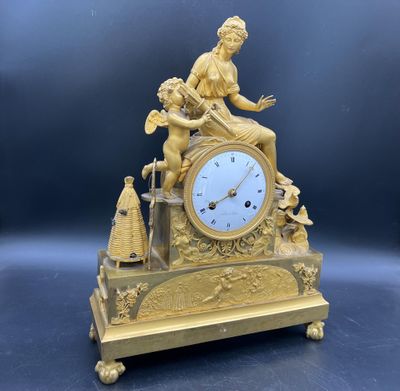 une horloge en or avec une femme assise dessus