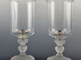 pair of clear glass candlesticks with a gold candle holder