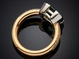 a close up of a gold ring with a green tourmaline and diamonds