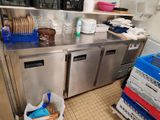 un plan de travail en inox sur lequel sont posés tout un tas de plats