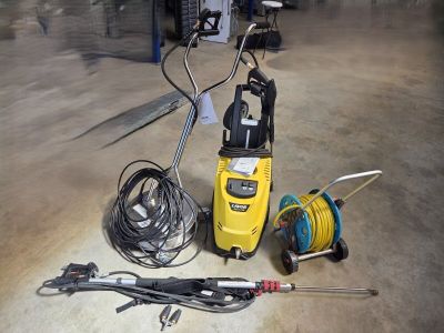 a power washer, hose, and other tools on the floor