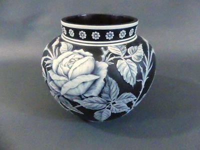un vase noir et blanc orné d'un motif de roses