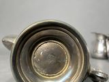 a silver cup sitting on a table next to a pair of silver cups