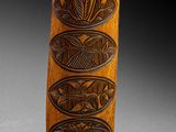 a close up of a wooden object with carvings on it