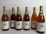 six bottles of wine are lined up in a row on a table