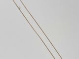 un collier en or avec une longue chaîne sur fond blanc