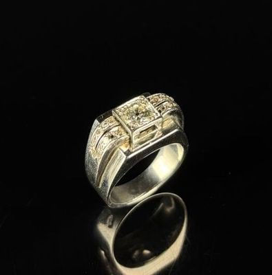 gros plan d'une bague en argent sur une surface noire