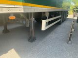 a green and yellow semi truck parked in a parking lot