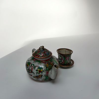 a small teapot and cup sitting on a table
