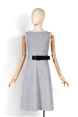 un mannequin portant une robe grise avec une ceinture noire