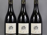 three bottles of wine are lined up on a table