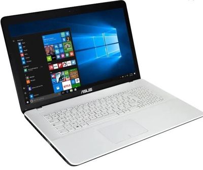 L'ordinateur portable Asus est ouvert sur une surface blanche, avec Windows affiché à l'écran.